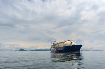 A small tanker on the roadstead bunkers a large LNG tanker. © vladsv