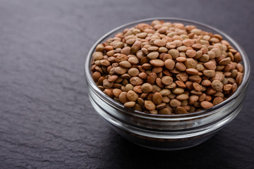 raw lentils on a dark stone background
