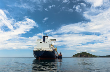 A small tanker on the roadstead bunkers a large LNG tanker.