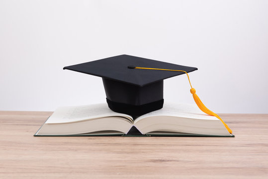 Black graduated tassel cap placed on the book.