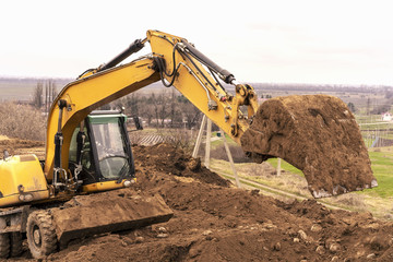  Excavator digging to moving the soil to the truck and adjusting ground level in construction site.