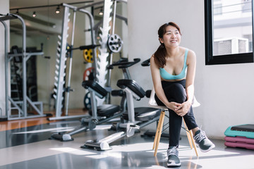 Women's exercise in fitness, relaxation gym, after sport training with dumbbell,Fitness woman taking a break after workout.
