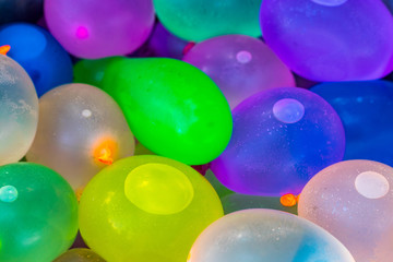 Many bright and colorful water balloons close up