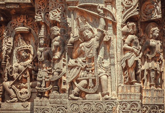 South Indian temple relief with hero Arjuna with bow and arrows in hands. Hindu structure from 12th century, Halebidu, India