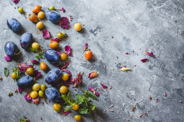 scattered blue and yellow plums on a gray background