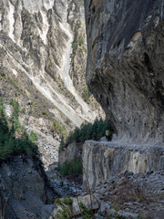 Fototapeta na wymiar Porters on a very steep trail above a river on Annapurna Circuit