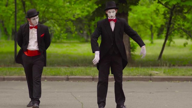 Two funny mimes do performance in the park