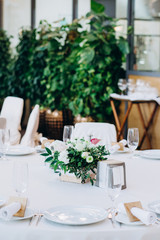 a wedding table with cutlery, candles and flowers.