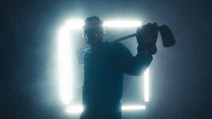 Obraz premium Portrait of Caucasian male ice hockey player in uniform, looking into the camera, dramatic lighting