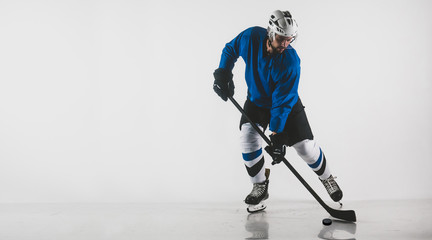 Obraz premium Portrait of Caucasian male ice hockey player in uniform performing a wrist shot against white background