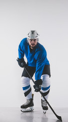 Portrait of Caucasian male ice hockey player in uniform posing against white background
