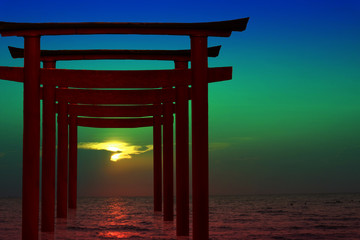 Fototapeta premium silhouette torii wooden Japanese pillar stand on sea sunset sky