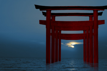 Fototapeta premium silhouette torii wooden Japanese pillar stand on sea sunset sky