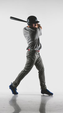 Caucasian professional baseball player batter wearing generic uniform posing as if he was hitting a ball isolated on white background