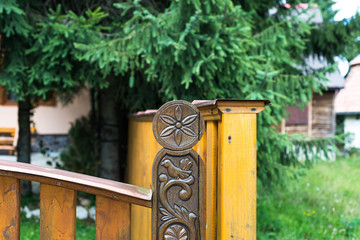 Carved sun , bird symbol on oak gate in front of residentual house.
