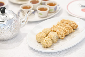 sesame dessert. A soft focus photo of Chinese sweet of sesame balls (sweet dumpling with black sesame filling inside) and fried taro served with ginger tea.