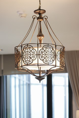 Chandelier. A vintage metal chandelier hanging down from the ceiling. Interior room decoration.