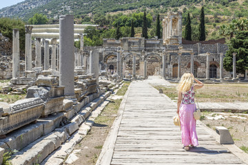Blonde woman walking in untere agora to library of Celsus in Ephesus, Izmir, Turkey