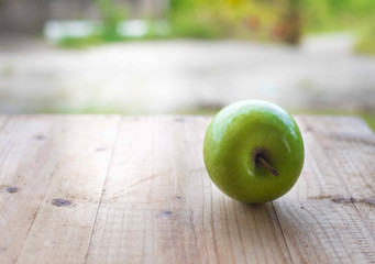 Green apple on wooden table. selective focus.