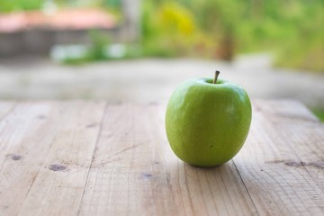 Green apple on wooden table. selective focus.