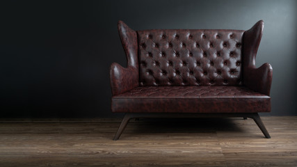 Sofa of black leather standing in center on concrete floor against dark grey wall with copy space....