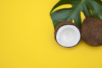 Tropical summer coconut background. half and whole coconuts on a yellow background