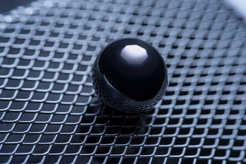 macro photo. metal ball on the background of iron grating