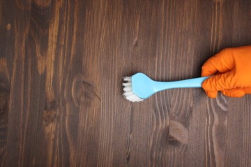 orange glove and brush on a wooden background