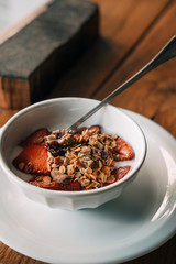 Yogurt with granola, strawberries on wooden coffee table. Hipster coffee shop. Food photography concept. Copy space