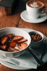 Yogurt with granola, strawberries on wooden coffee table. Hipster coffee shop. Food photography concept. Copy space