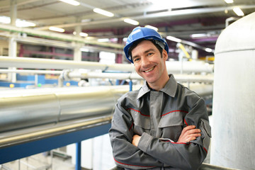 portrait of successful workman in an industrial company, in working clothes at the workplace  -...