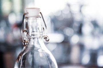 Glass bottle contained mineral water in blurred background.
