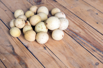 Lansium parasiticum, also known as langsat on the wooden table