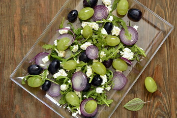Salad with various grapes, goat cheese, purple onion, arugula, top view