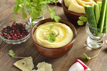 Healthy hummus dip with olive oil and pita bread and vegetables