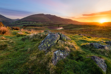 Stunning sunrise with beautiful morning light illuminating rocks in the Lake District.