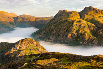 Morning light shining on Lake District mountains with cloud inversion.