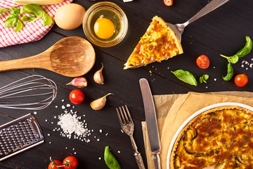 A piece Homemade quiche lorraine with chicken, mushrooms and cheese, kitchenware and ingredients
