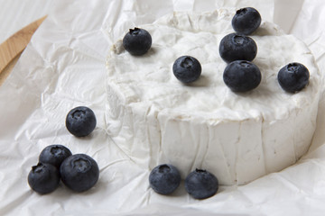 Camembert cheese in paper, close-up. Milk production.