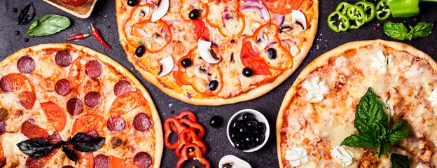Foto op Canvas selectie van verschillende pizza& 39 s op een zwarte achtergrond en ingrediënten. Peperoni, Vegetarische en Zeevruchten Pizza © colnihko