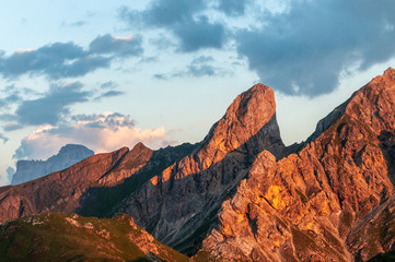 Sunset at the Passo di Giau, casting a red glow on the rugged mountains of the Italian Dolomites, on a late July evening.