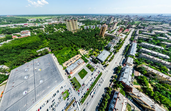 Aerial city view with crossroads and roads, houses, buildings, parks and parking lots, bridges. Helicopter drone shot. Wide Panoramic image.