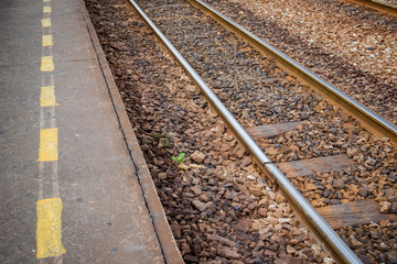 Obraz premium Photograph of rail station platform with safety yellow line.
