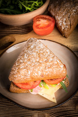 Triangular sandwich with cheese, ham and tomato.