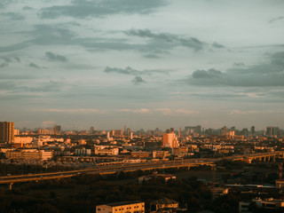 Cityscape of unknow city with thick clouds and sunset light.