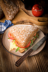 Triangular sandwich with cheese, ham and tomato.