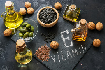 Food rich in vitamin E. A set of different oils. Seeds of flax, sunflower, walnut, olives. Top view.