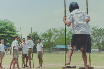 Student try to  walk on the Bamboo legs,Children playing Old tha