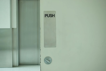 Black text push sign on white door