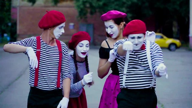 Four comic mimes imitate car accident at the city